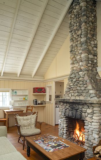 Cozy room with a stone fireplace, wood on the floor, puzzle on the