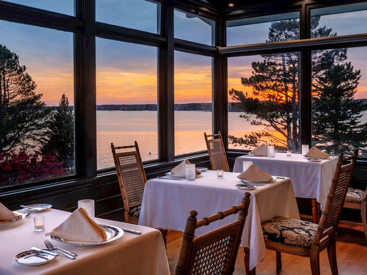 Restaurant with lake view at sunset, tables set for dining.